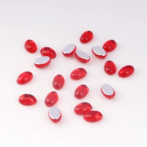 Macro shot of 4x6mm oval acrylic gems with polished red top and silver metallic flat base