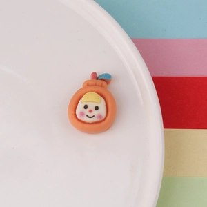 Macro shot of resin orange fruit charm with cartoon girl face for DIY crafts