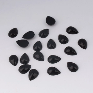 Macro view of 7x10mm black teardrop flatback acrylic stones for DIY jewelry crafts