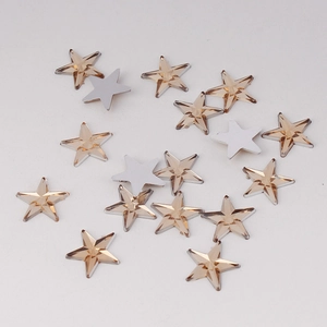 Macro shot of 10mm champagne gold star-shaped acrylic rhinestones with faceted surface
