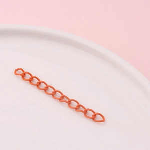 Detailed macro view of orange matte finish metal extension chain for DIY jewelry making
