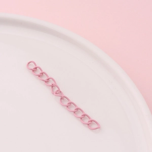 Close-up of pink painted metal extension chain with oval links for DIY jewelry making