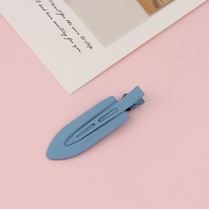 Macro detail of matte fog blue hair clip on soft pink background with decorative card