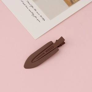 Macro detail of a coffee brown matte duckbill hair clip with sleek hollow design