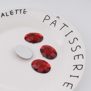 Detail of red oval faceted acrylic rhinestones with flat back for DIY crafts