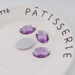 Macro shot of 18x25mm purple oval faceted acrylic rhinestones with flat silver backing