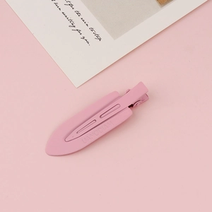Detail view of pink matte duckbill hair clip with logo and metal spring mechanism