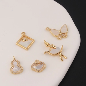Detailed macro view of gold-plated ballet girl and butterfly shell pendants with zircon