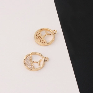 Detail of gold-plated fish tail pendants with micro-pave cubic zirconia and relief texture