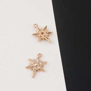 Macro detail of gold North Star charms with sparkling cubic zirconia insets