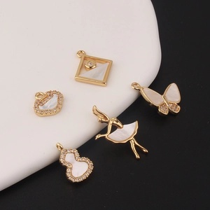 Five gold-plated jewelry pendants featuring white shell butterfly and ballet girl motifs