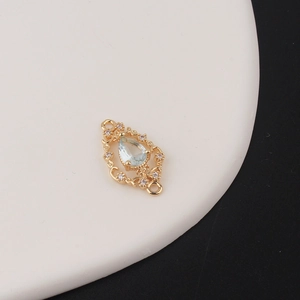 Detailed view of teardrop zircon pendant with light blue stone and gold filigree