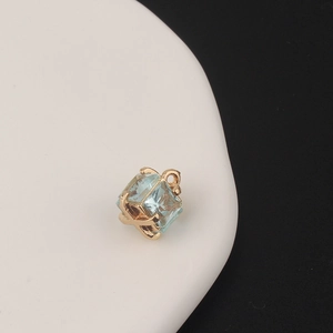 Close-up of a square light blue zircon pendant with gold-plated claw setting for DIY jewelry