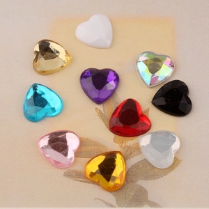 Macro view of 12mm faceted acrylic heart rhinestones in various colors for DIY crafts