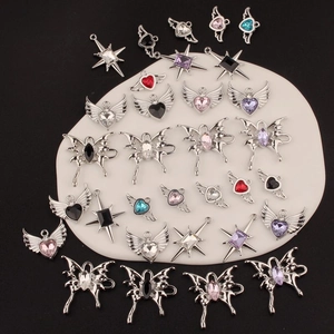 Detailed macro view of assorted Y2K style alloy heart, butterfly, and cross charms
