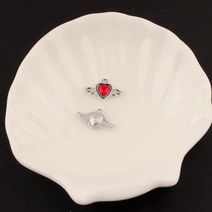 Detail of silver heart wing pendants with red gemstone for DIY jewelry making
