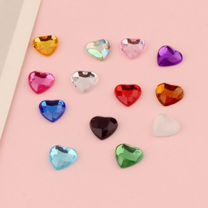 Dettaglio macro di strass acrilici colorati a forma di cuore per gioielli artigianali