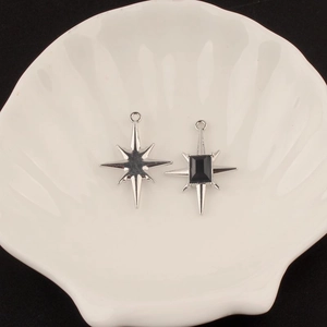 Macro detail of Y2K starburst alloy pendants with black gemstone for DIY jewelry making