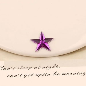Macro detail of a 20mm purple star-shaped acrylic flatback gem with geometric facets