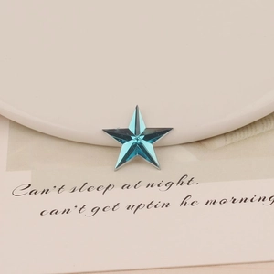 Macro view of blue star-shaped acrylic crystal with faceted surface for DIY jewelry