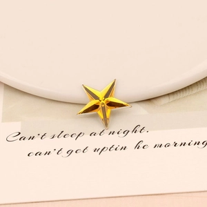 Macro detail of amber star-shaped acrylic rhinestone with faceted cut for DIY crafts
