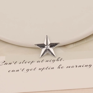 Detailed macro view of star-shaped 20mm faceted acrylic gem with silver metallic luster