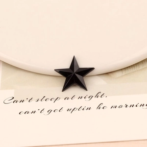 Detailed macro view of a 20mm black star acrylic flatback rhinestone with 3D faceted cut