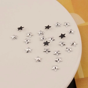Macro detail of 6mm star acrylic rhinestones in silver and black for nail art and DIY craft