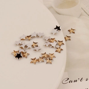 Macro shot of 6mm silver and champagne gold star acrylic flatback rhinestones for DIY crafts