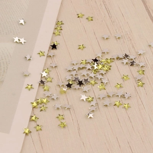 Détail macro de minuscules paillettes pour ongles en forme d'étoile de 3mm en argent et jaune