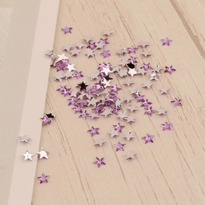 Vue détaillée de cristaux en forme d'étoile de 3mm pour nail art sur fond de bois