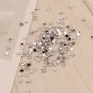 Gros plan de paillettes d'ongles en métal argenté de 3 mm sur un bureau en bois clair