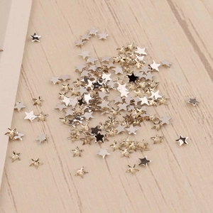 Détail macro de breloques étoiles en métal de 3 mm pour nail art en argent et or