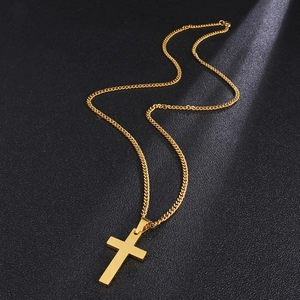 Detailed close-up of a polished gold stainless steel cross pendant with cuban chain