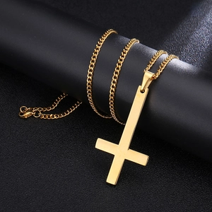 Detailed close-up of a large gold inverted cross pendant with high-polished Cuban chain