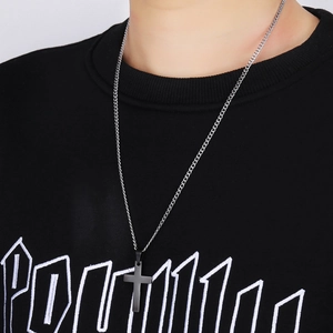 Men wearing a matte black cross pendant necklace with a slim silver metal chain