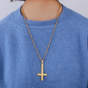 Detailed view of a polished gold St. Peter inverted cross pendant on a classic O-chain
