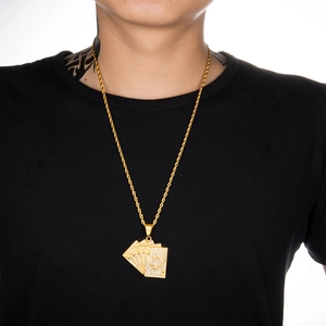 Detail of hip hop gold rope chain featuring iced out poker card pendants on a model