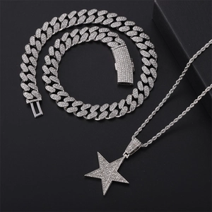 Conjunto hip-hop de cadena cubana plateada y gran colgante de estrella helada sobre fondo negro