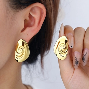 Orecchini a cerchio dorati ovali con trama a spirale per un look minimalista