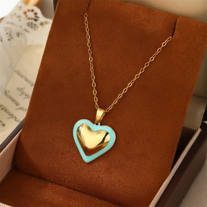 Détail du pendentif coeur avec bordure en émail bleu sur une chaîne à maillons dorés