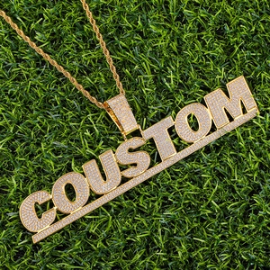 Macro shot of custom iced-out COUSTOM gold-plated hip hop pendant with zircon micro-pave
