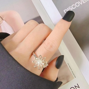 Eleganter S925 Silberring mit drehbarer Blume, weißer Perle und Zirkon am Finger eines Models