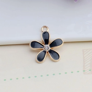 Macro detail of alloy flower charm with black enamel petals and center rhinestone