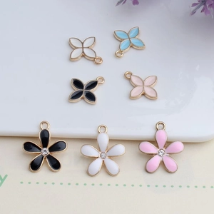 DIY jewelry charms in clover and flower shapes with enamel finish and small rhinestones