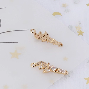 Detailed macro view of gold-plated crescent moon and star pendant with white zircon inlays