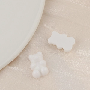 Macro shot of white resin cartoon bear charms for DIY handmade crafts and hair accessories