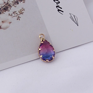 Vue macro d'un pendentif en cristal en forme de larme avec dégradé violet-bleu et bordure dorée