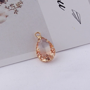 Gros plan d'un pendentif en cristal de goutte champagne avec sertissage à griffes dorées