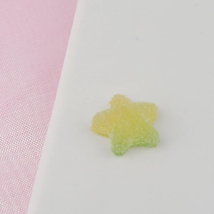 Macro shot of yellow and green gradient star resin accessory with sugary texture